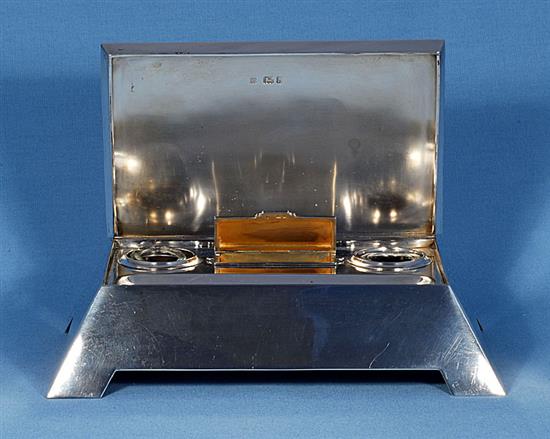 A stylish Edwardian silver inkstand with hinged cover, by length approx 11 ½”/292mm depth 7 ¾”/197 mm. Weight 57ozs/1613grms.